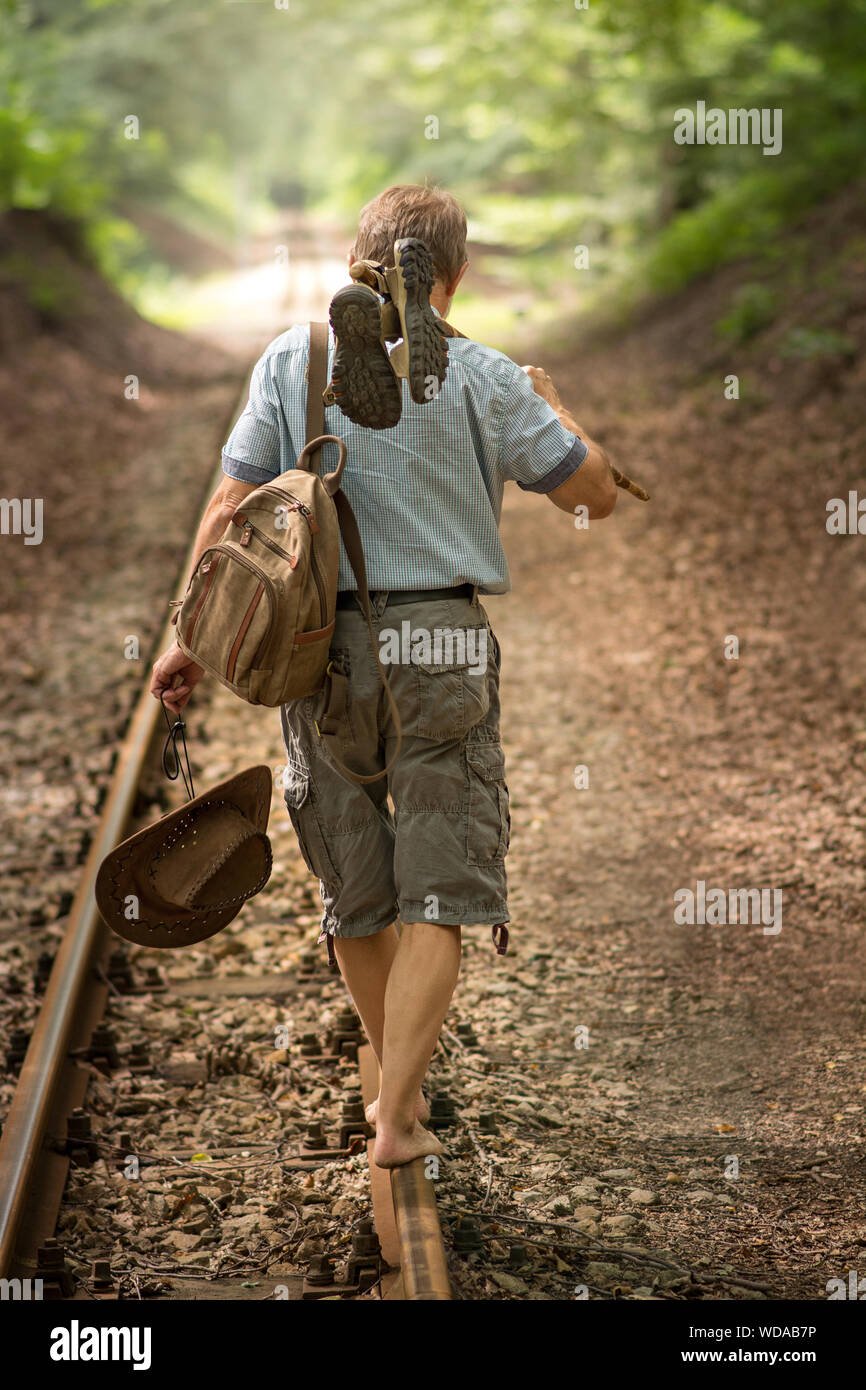 Vieil homme marche sur railroad Banque D'Images