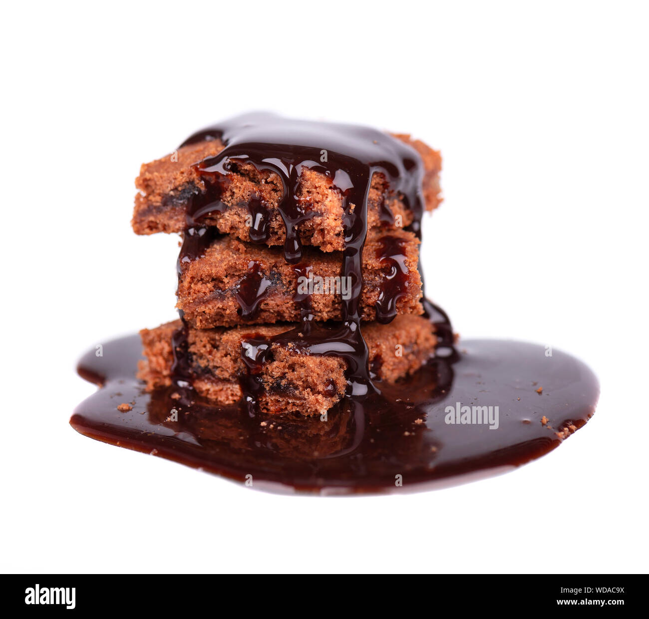Tranches de brownie, isolé sur fond blanc, couvert de sirop au chocolat noir. Banque D'Images