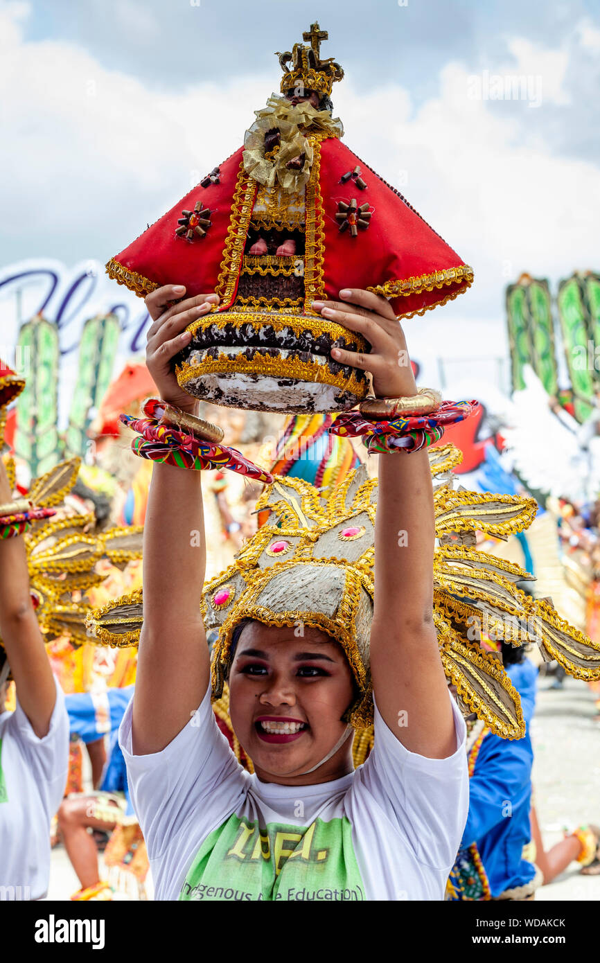 Une jeune femme nous tend un Santo Nino Statue Au cours de la danse tribale Dinagyang, Festival, la Ville d'Iloilo, aux Philippines, l'île de Panay Banque D'Images