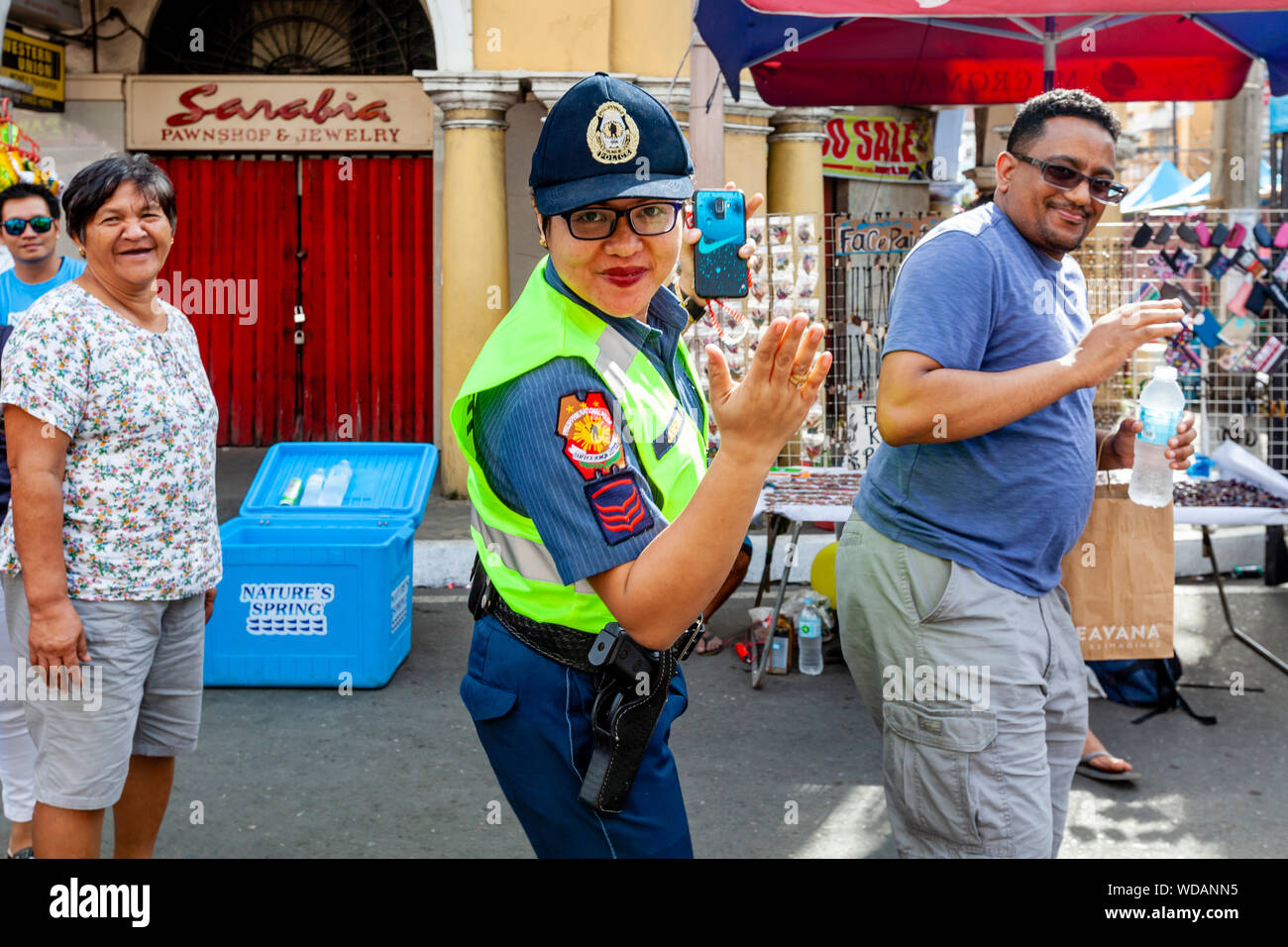 Une femme policier danses dans la rue avec les fêtards durant le Festival Dinagyang Festival, la Ville d'Iloilo, aux Philippines, l'île de Panay Banque D'Images
