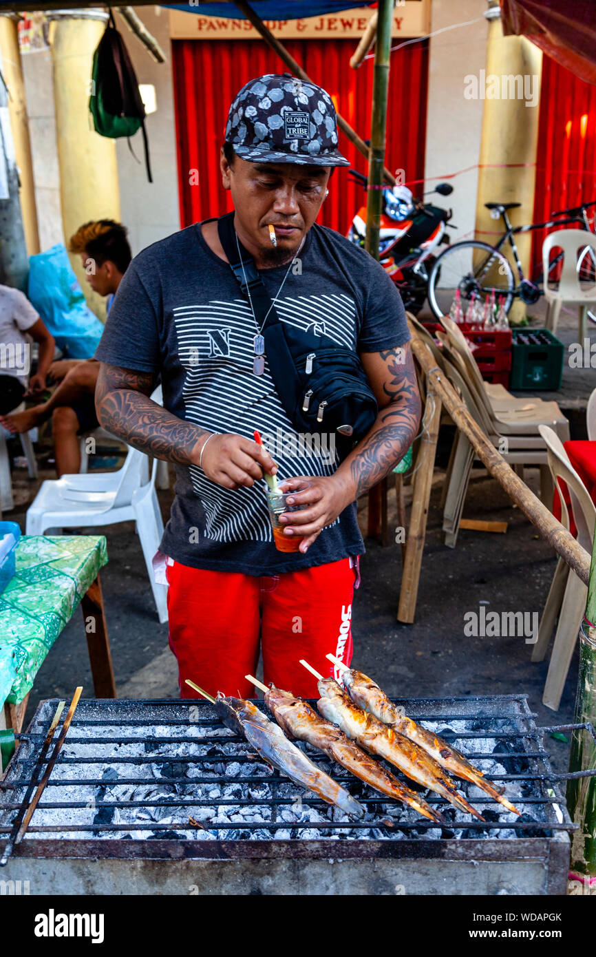 Un homme de son pays sur un poisson cuit au grill Dinagyang Festival, la Ville d'Iloilo, aux Philippines, l'île de Panay Banque D'Images