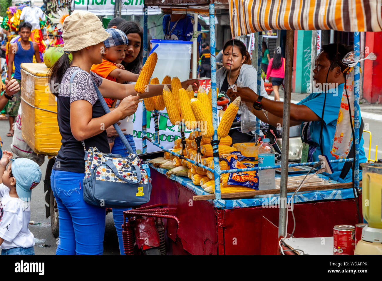 Les femmes philippines l'achat et la vente de maïs pendant la Festival Dinagyang, la Ville d'Iloilo, aux Philippines, l'île de Panay Banque D'Images