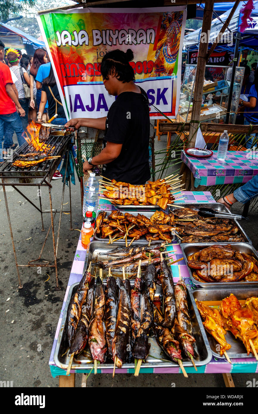 L'alimentation de rue philippine, un homme de son pays la cuisson du poisson sur un grill, Dinagyang Festival, la Ville d'Iloilo, aux Philippines, l'île de Panay Banque D'Images