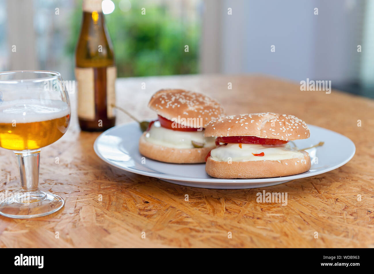 Home made burgers au fromage sur la plaque et le verre de bière. Image horizontale. Banque D'Images