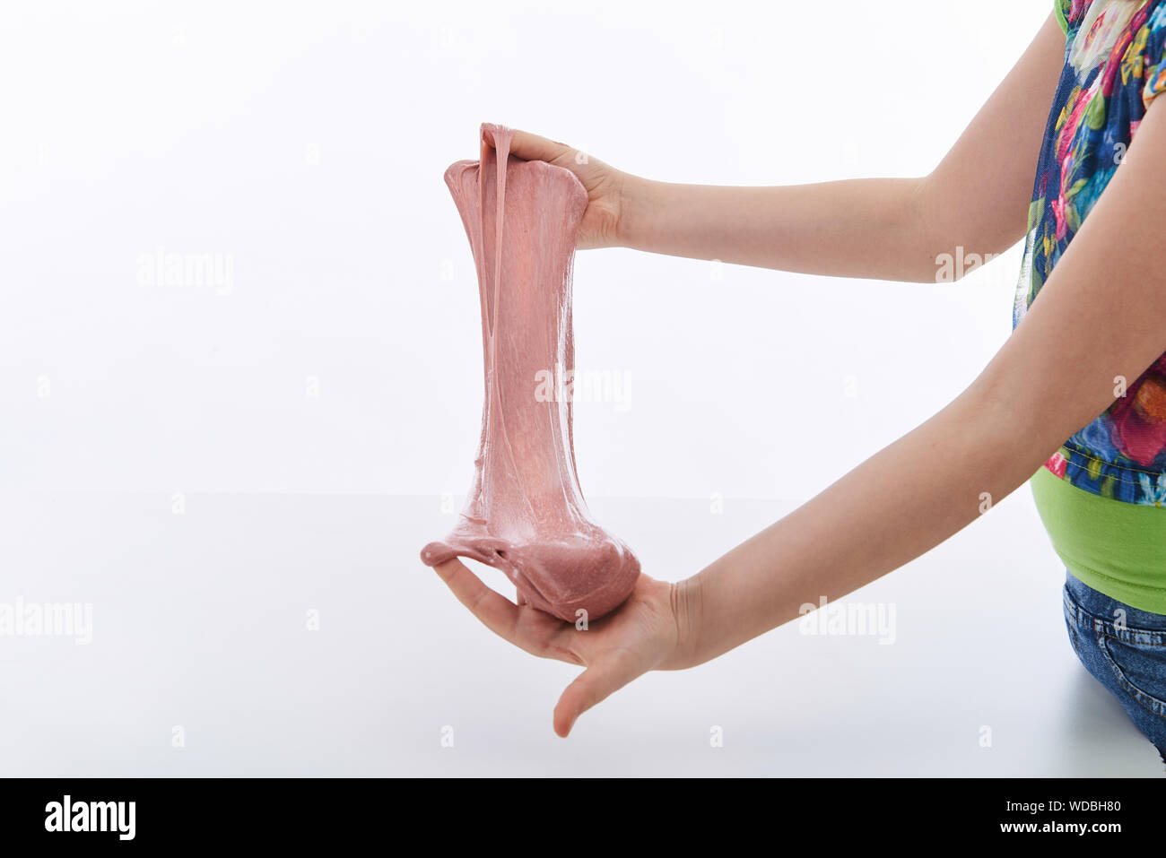 Jeune fille jouant avec du mucus. Image horizontale. Fond blanc Banque D'Images