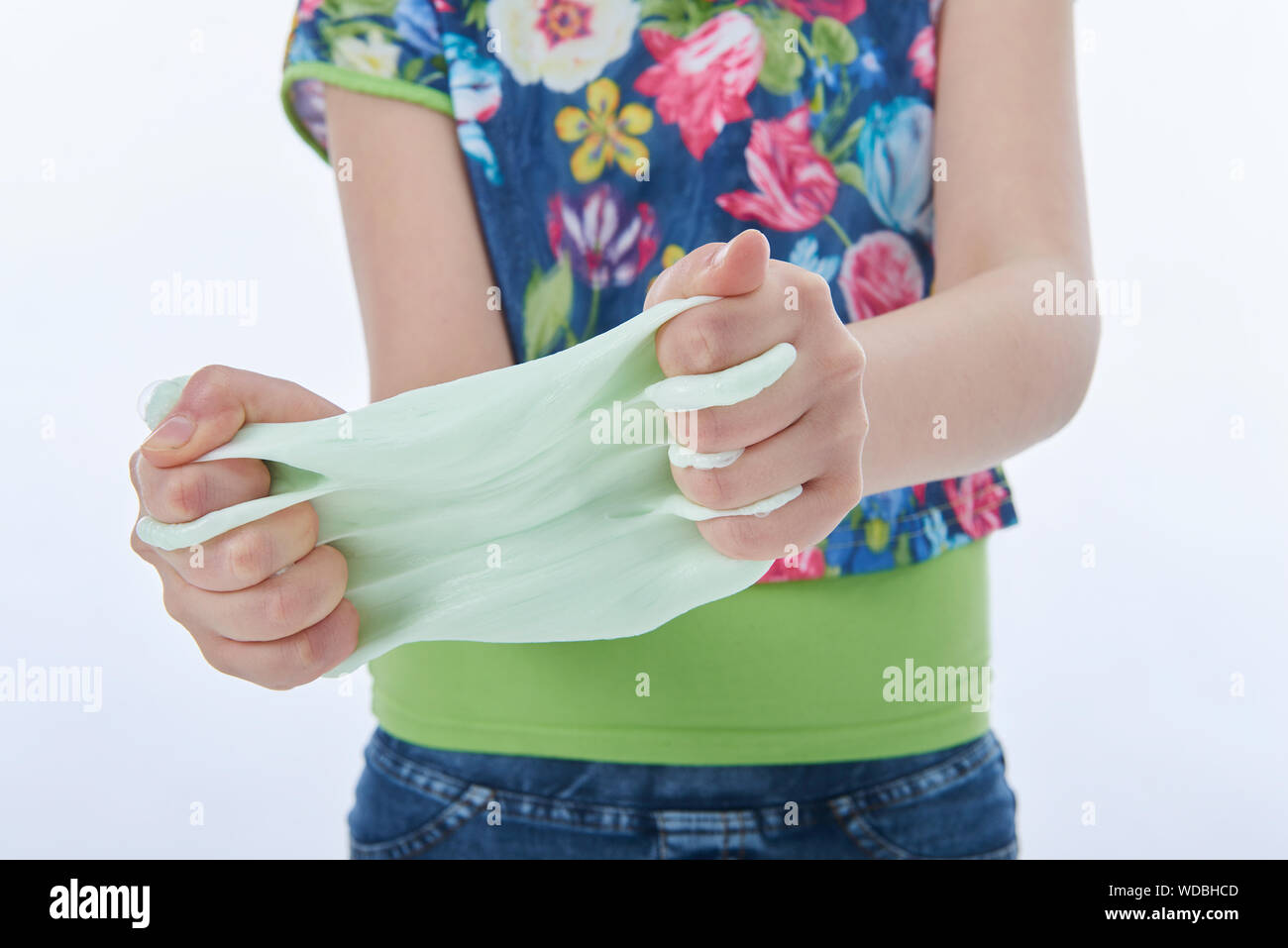 Jeune fille jouant avec du mucus. Image horizontale. Fond blanc Banque D'Images
