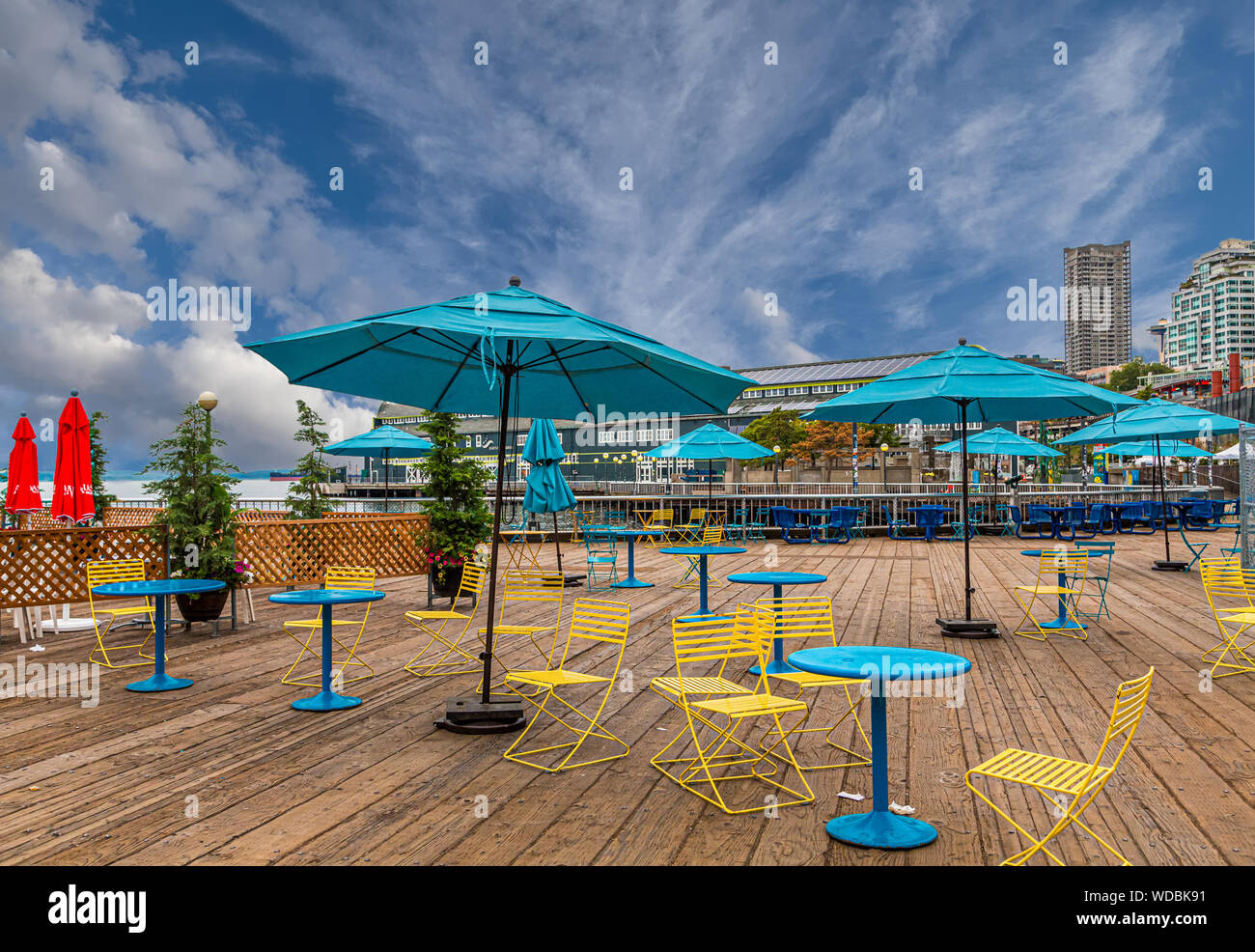 Chaises jaune Sarcelle avec des parasols et des tables sur la terrasse en bois Banque D'Images