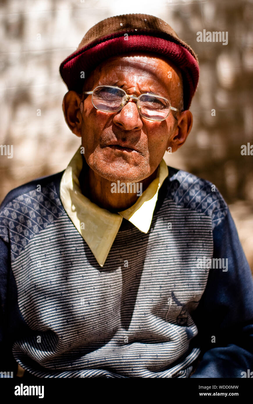 Homme assis à l'extérieur un monastère au Tibet Banque D'Images