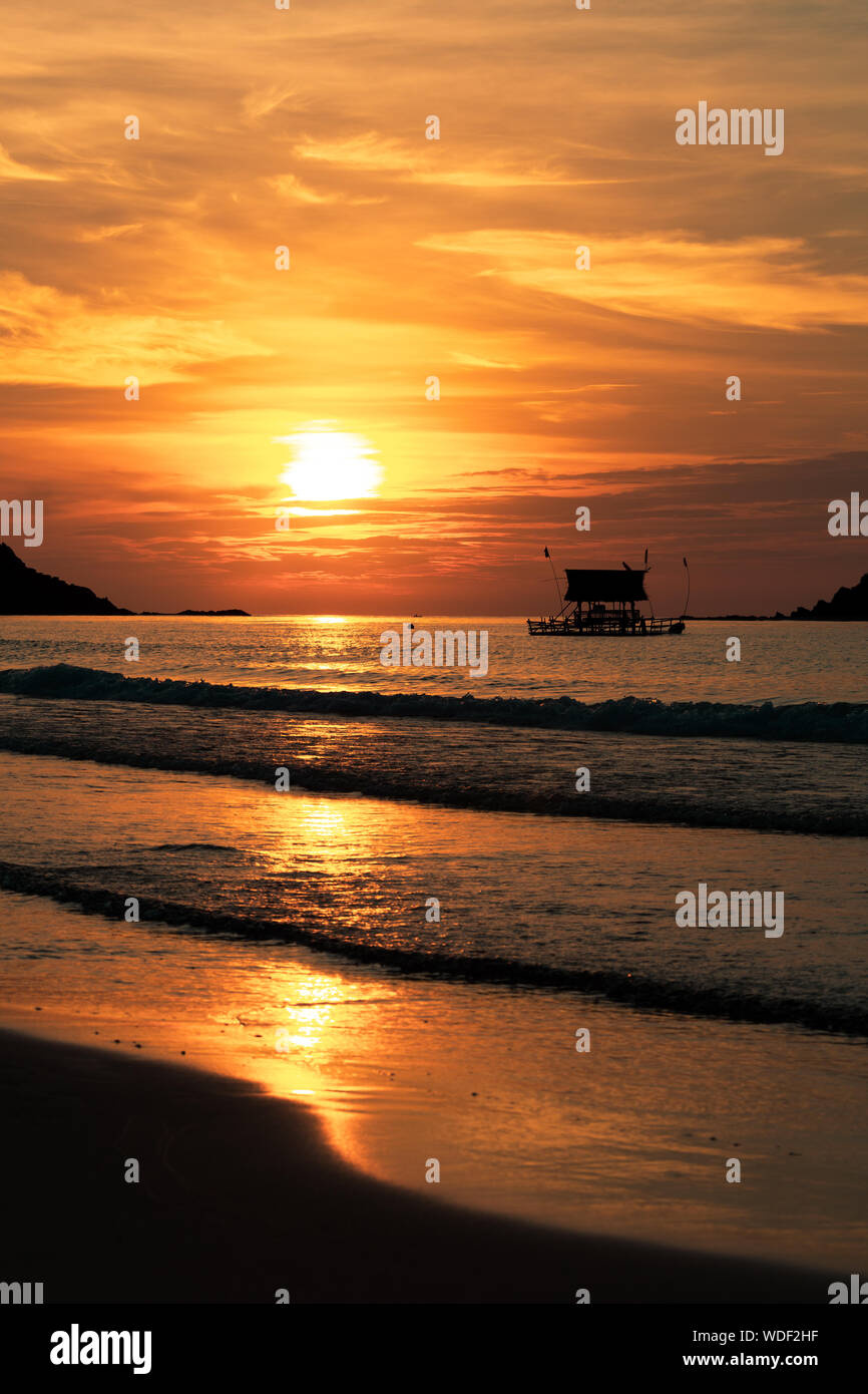 La silhouette du navire sur un fond de coucher du soleil doré. Le coucher du soleil, aux Philippines. Sur le bord de la mer. La verticale. Banque D'Images