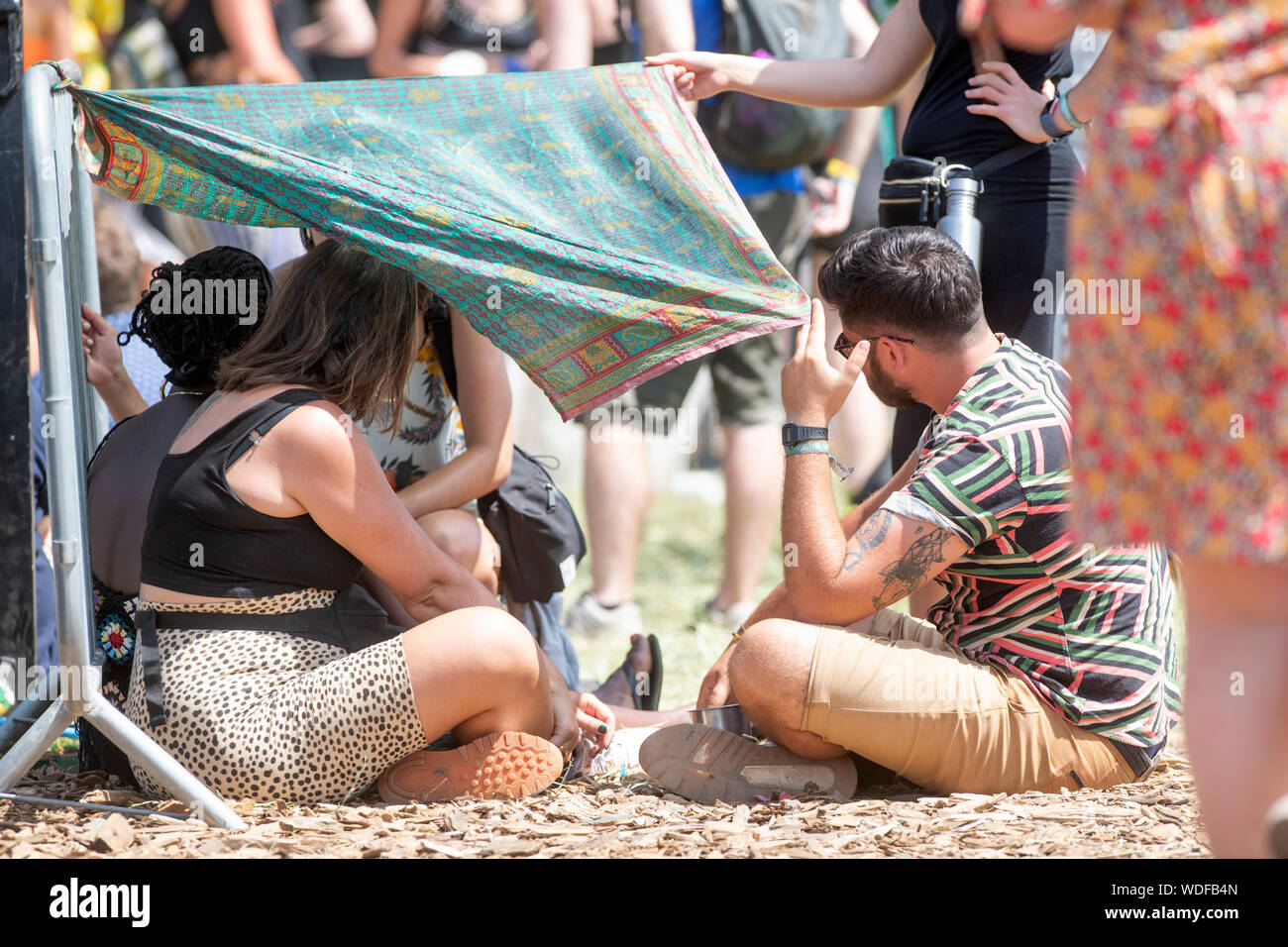 Fêtards s'improviser quelque ombre en utilisant un sarong près de l'autre étape au festival de Glastonbury 2019 dans Pilton, Somerset Banque D'Images
