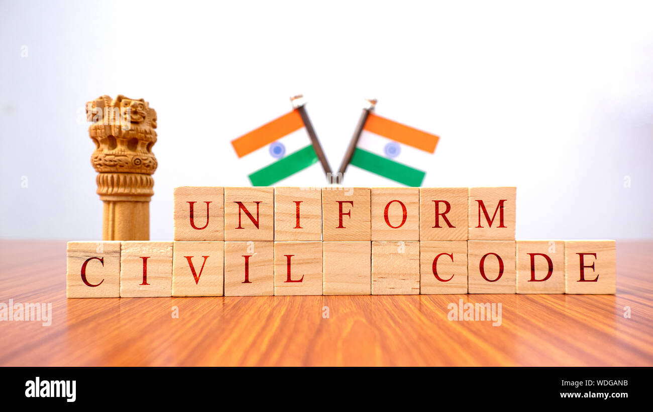 Concept d'une loi pour tous appelé code civil uniforme ou UCC dans la constitution indienne en bloc en bois lettres et drapeau indien comme arrière-plan. Banque D'Images