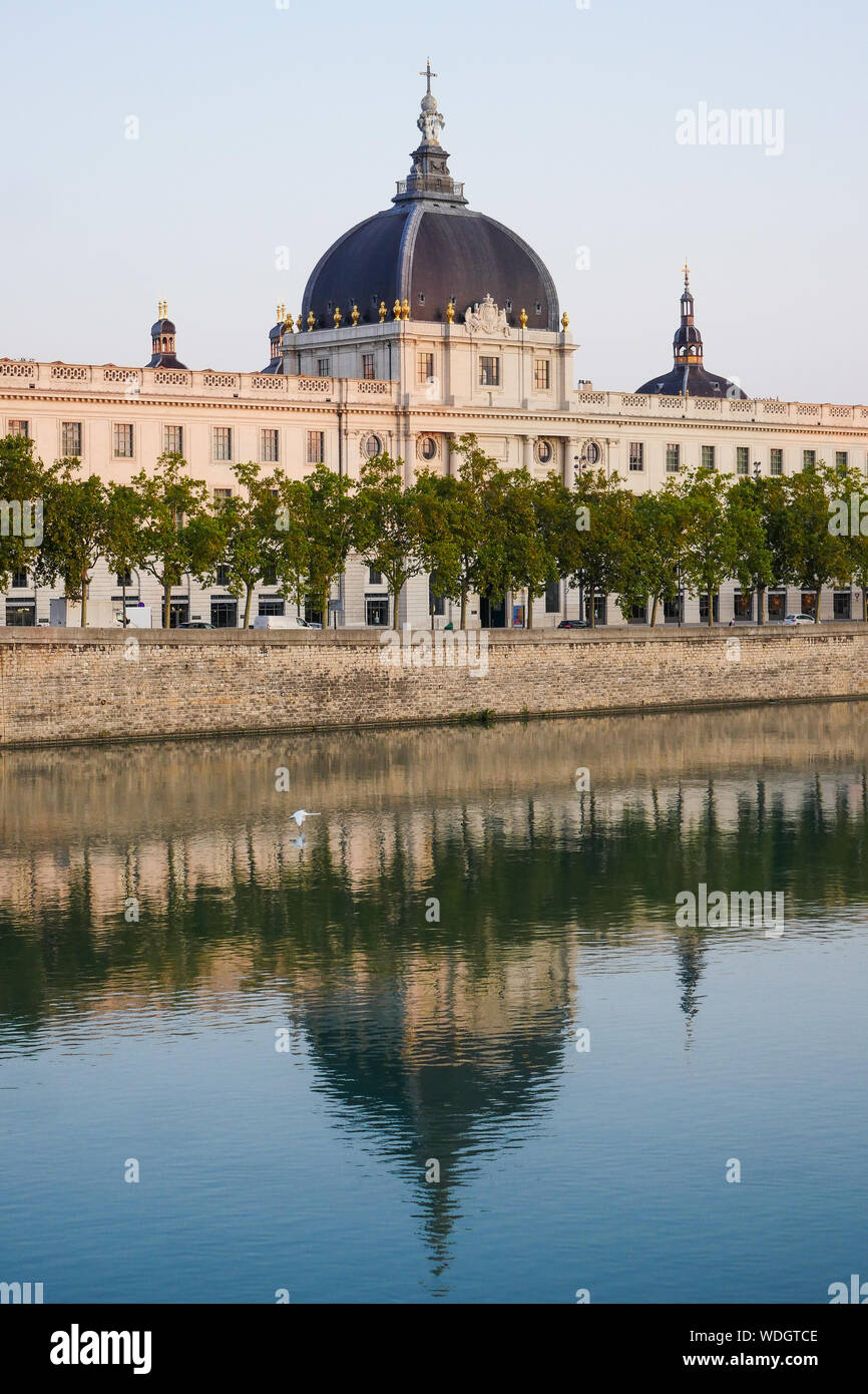 Façade du Grand Hôtel-Dieu se reflétant dans les eaux du Rhône au lever du soleil, Lyon, France Banque D'Images