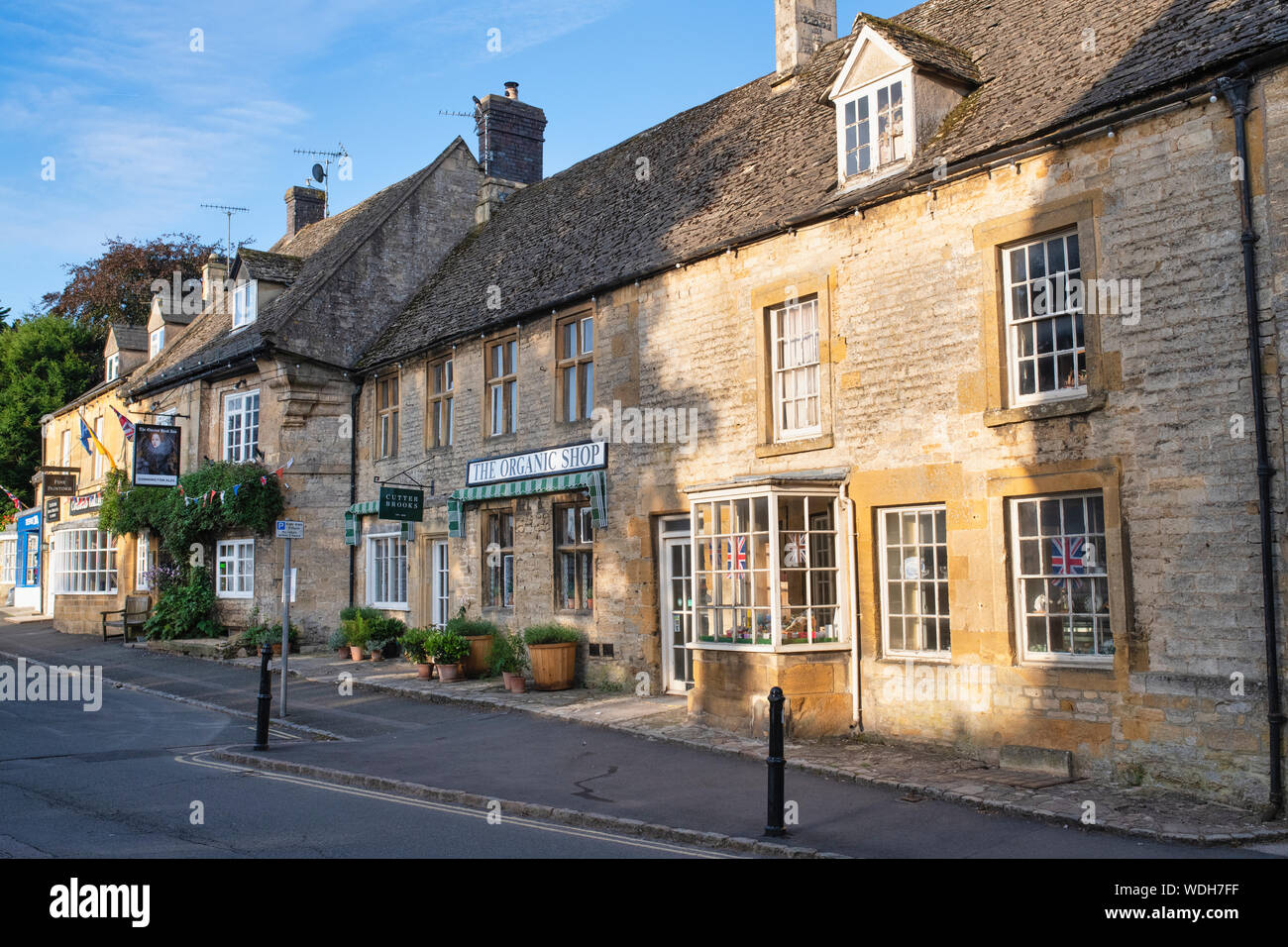 La boutique bio et le Queens Head Inn sur le marché. Stow On The Wold, Cotswolds, Gloucestershire, Angleterre Banque D'Images