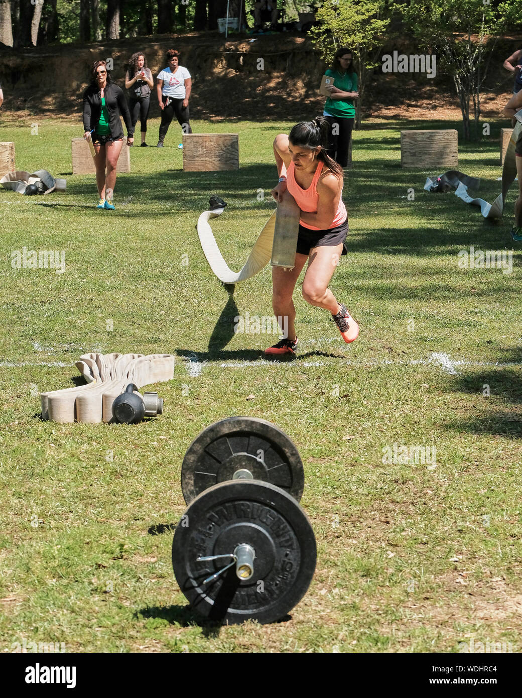 Femme ou une femme en compétition dans un concours défi fitness CrossFit de l'épuisement à l'extérieur dans l'Alabama, USA. Value Place Beaumont Banque D'Images