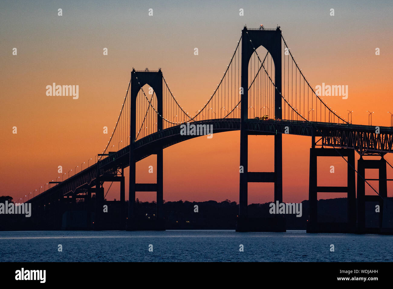 Silhouette du pont Claiborne Pell de Newport contre un ciel orangé au coucher du soleil sur la baie de Narragansett, Newport, Rhode Island, États-Unis. Banque D'Images