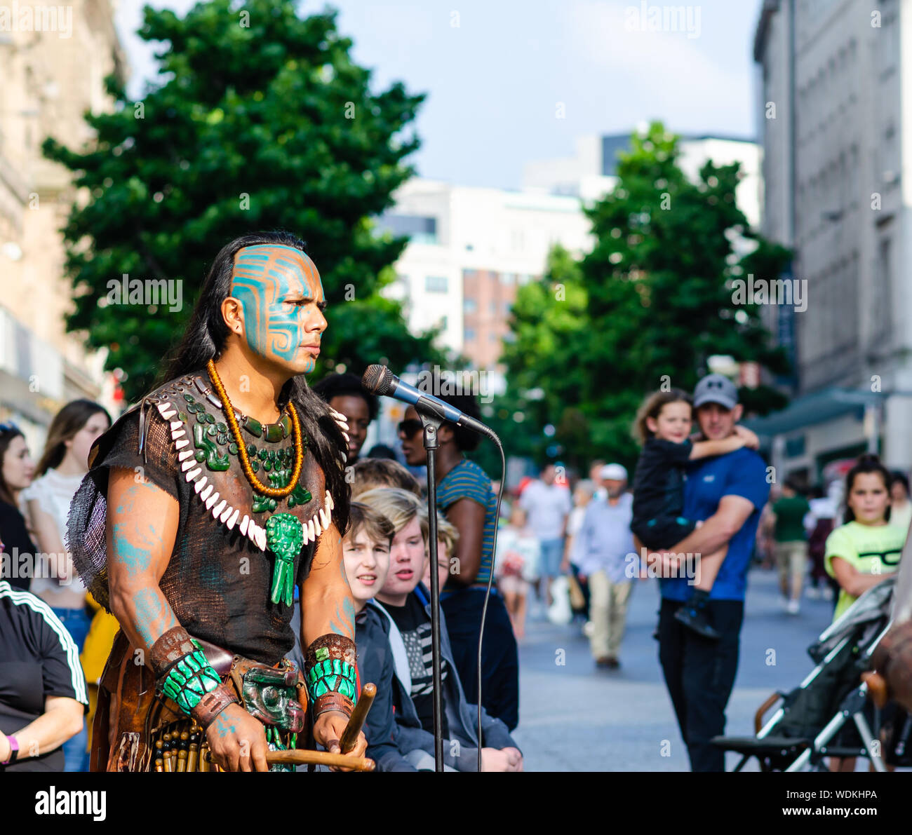 Guerrier maya joue du tambour. Artiste de théâtre rituel Maya du Mexique sur la rue de Liverpool. L'artiste porte le costume traditionnels mayas. Banque D'Images