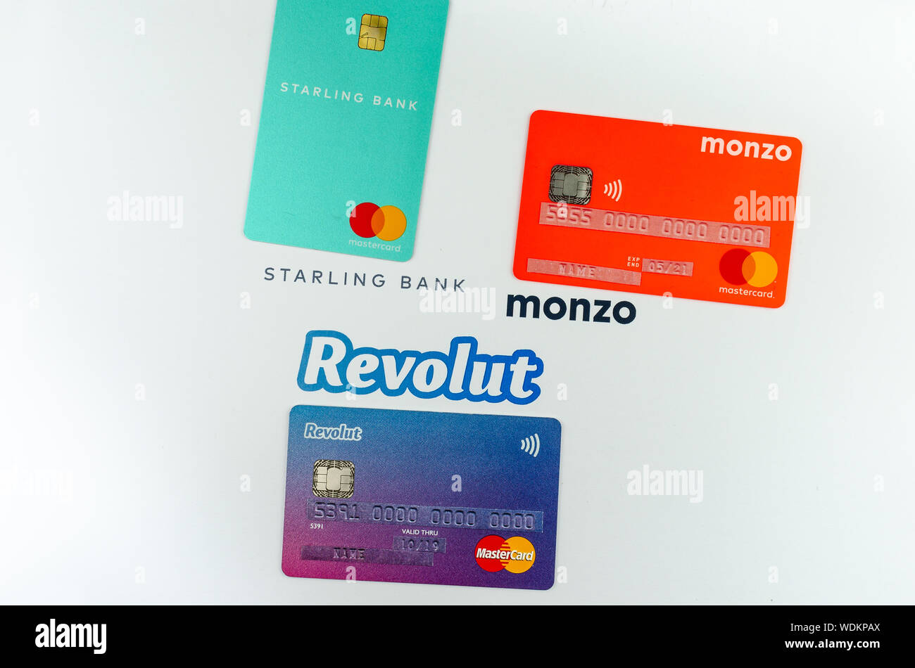 Starling, Monzo, Revolut cartes bancaires placés les uns à côté des autres. Concept pour la concurrence. L'information sensible est recouverte d'autocollants avec faux chiffres. Banque D'Images