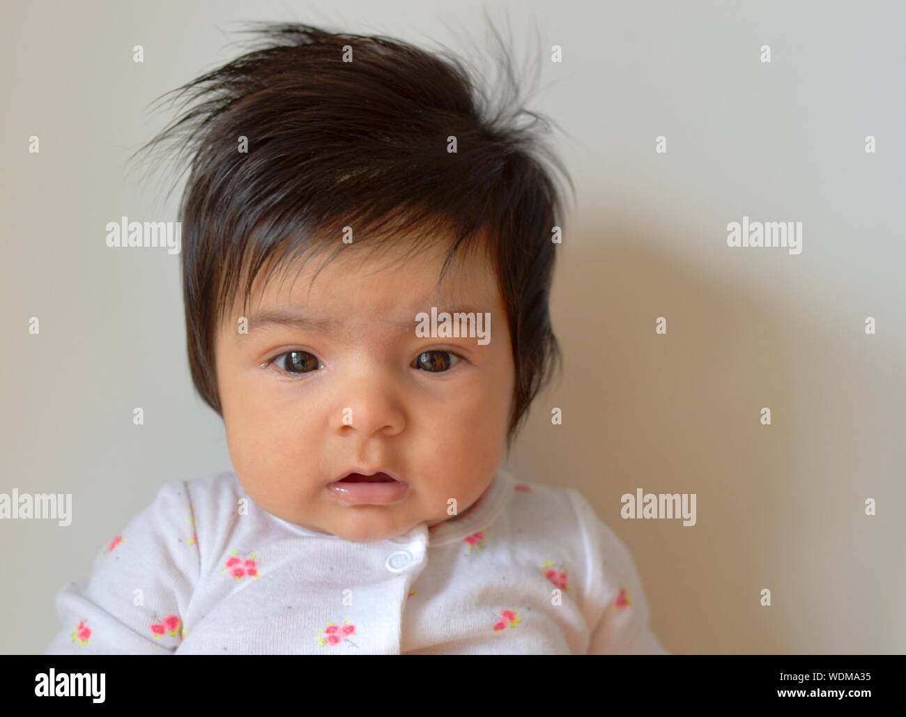 6 mois bébé fille avec de longs cheveux vers le bas avec la bouche ouverte Banque D'Images