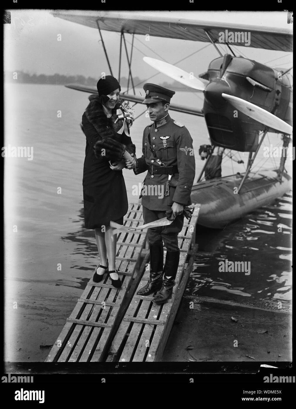 Au revoir et bonne chance. Après le baptême en hydravion qui le Lieut. Benjamin Mendes, de la Colombie, va tenter un vol de Far Rockaway, New York), à la Colombie, Mlle Maria Olaya, fille du ministre de la Colombie aux États-Unis, l'offre à la brochure Bon voyage. L'avion a été baptisé Ricaurte en l'honneur de l'un des fameux généraux Abstract/moyenne : 1 négative : 4 x 5 in. ou moins Banque D'Images