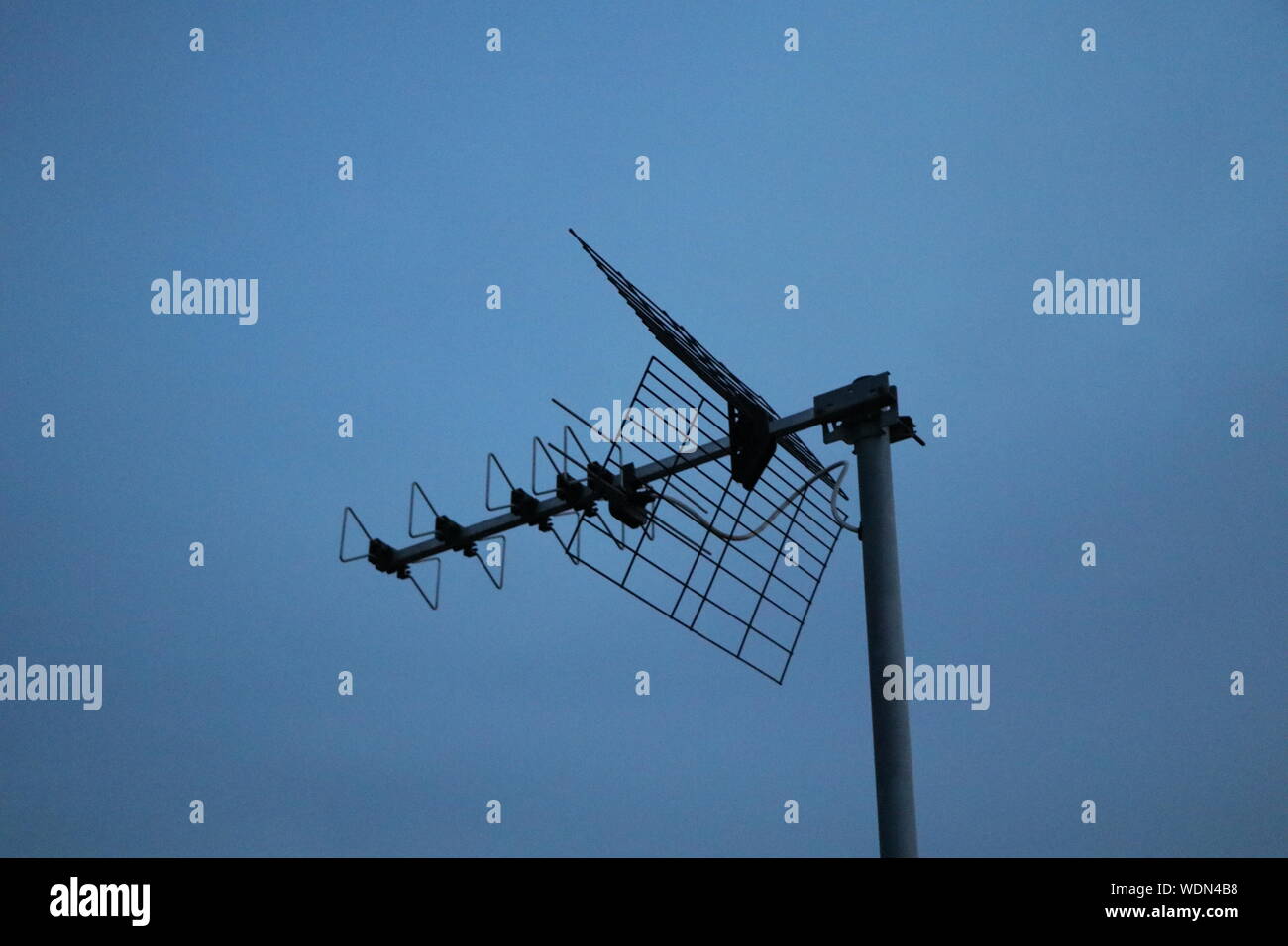 Antenne TV sur un toit, sur un fond de ciel bleu Banque D'Images
