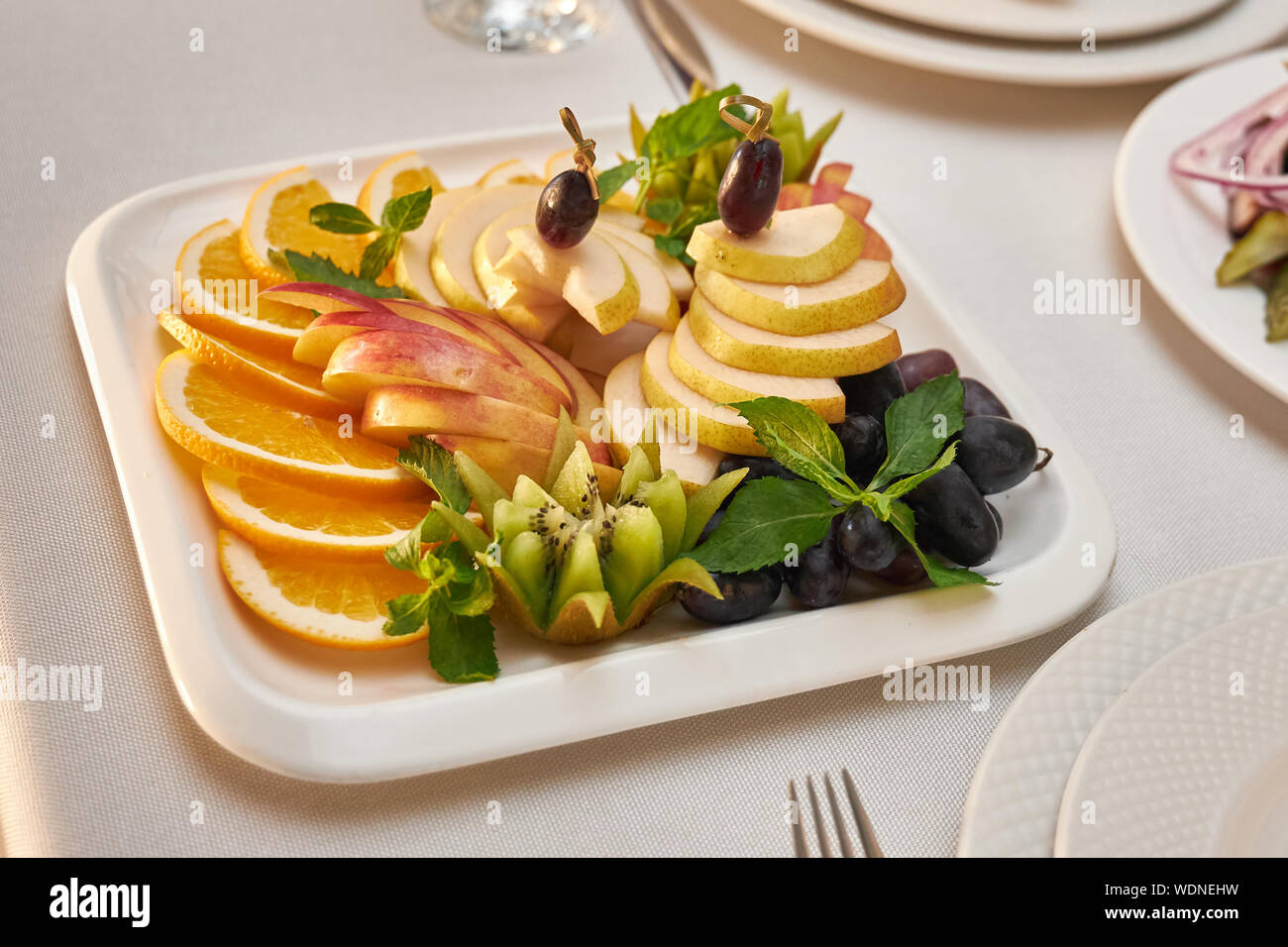 Plaque avec tranches de fruits est servi sur une table dans un restaurant. Banque D'Images