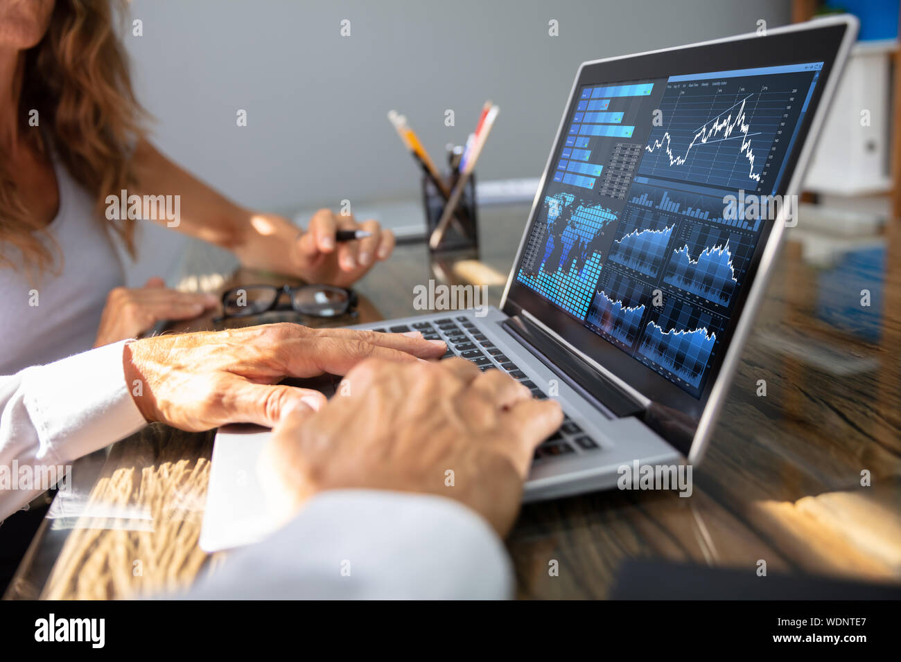 Close- Up d'employés de bureau de l'analyse graphique sur ordinateur portable avec son collègue. Banque D'Images
