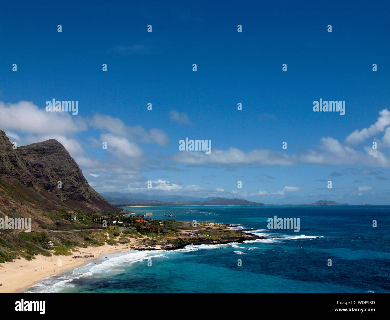 Les vagues déferlent sur Makapuu Beach avec la gamme Koolau montagnes au-dessus de regarder vers Kailua Bay sur la côte au vent d'Oahu, Hawaii. Banque D'Images