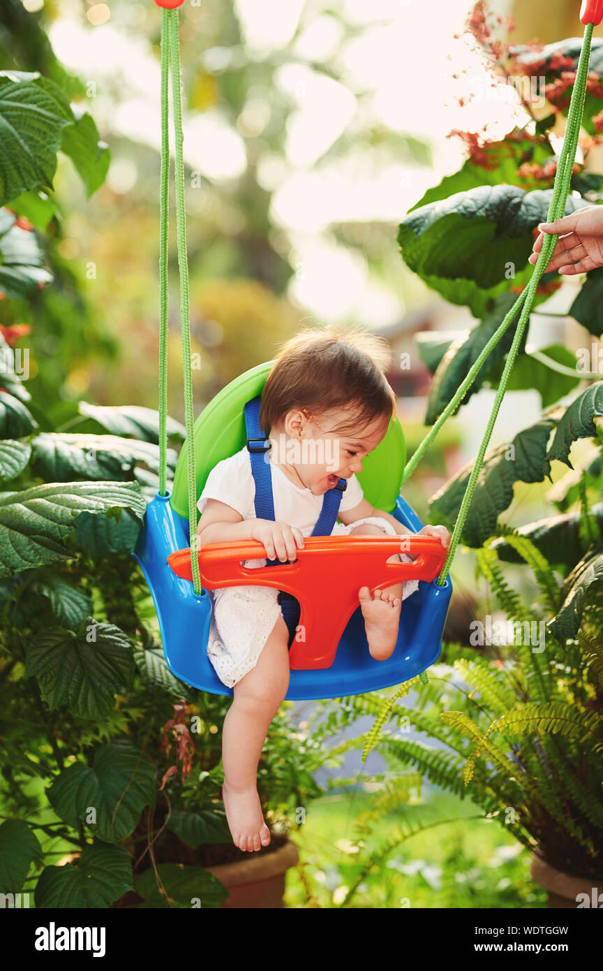 Baby Girl playing parc avec balançoires sur arrière-plan flou Banque D'Images