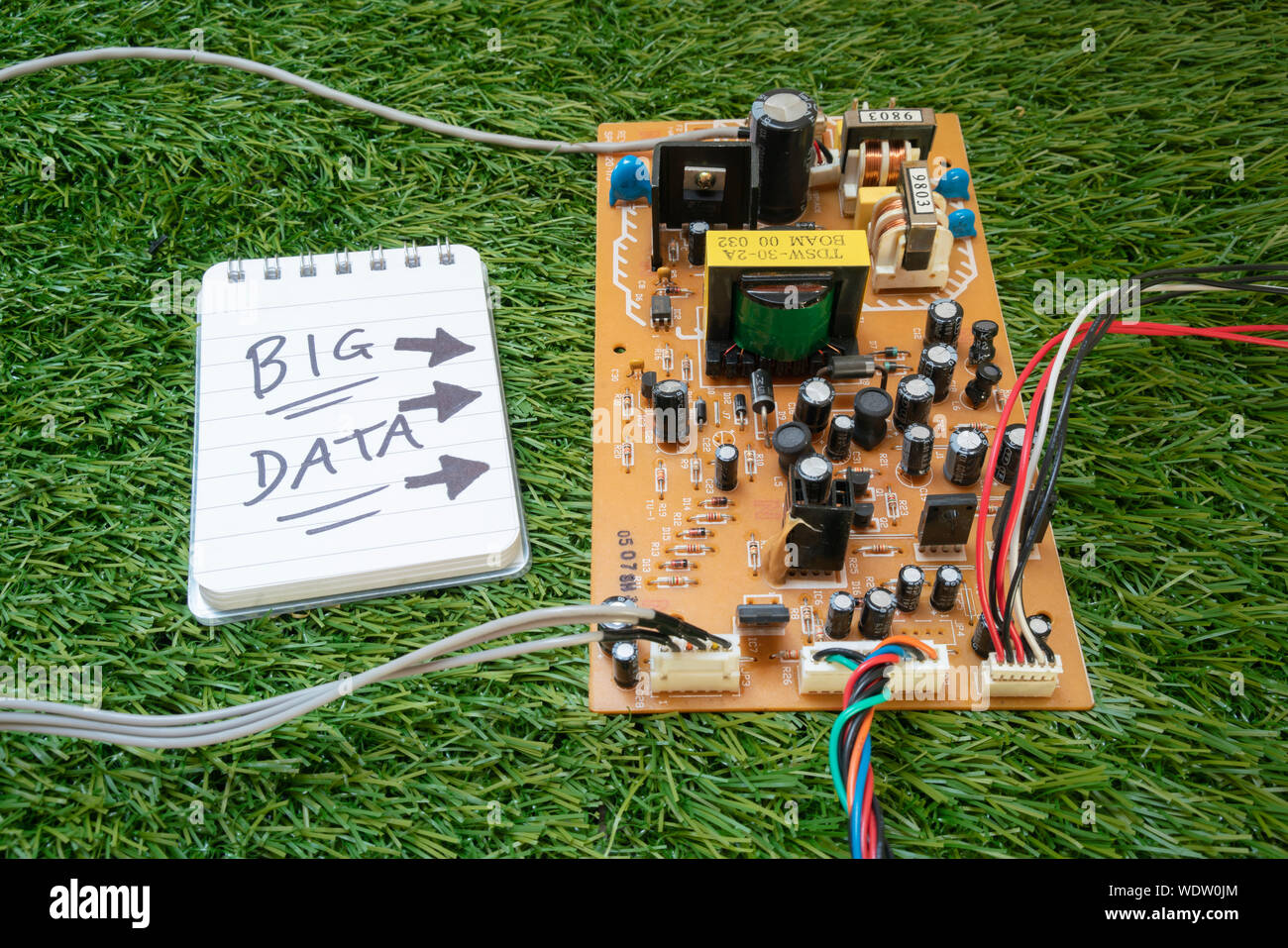 Un circuit électronique et les fils, avec un bloc-notes à lire 'Big Data' sur l'herbe. Les données d'un parc ? Banque D'Images
