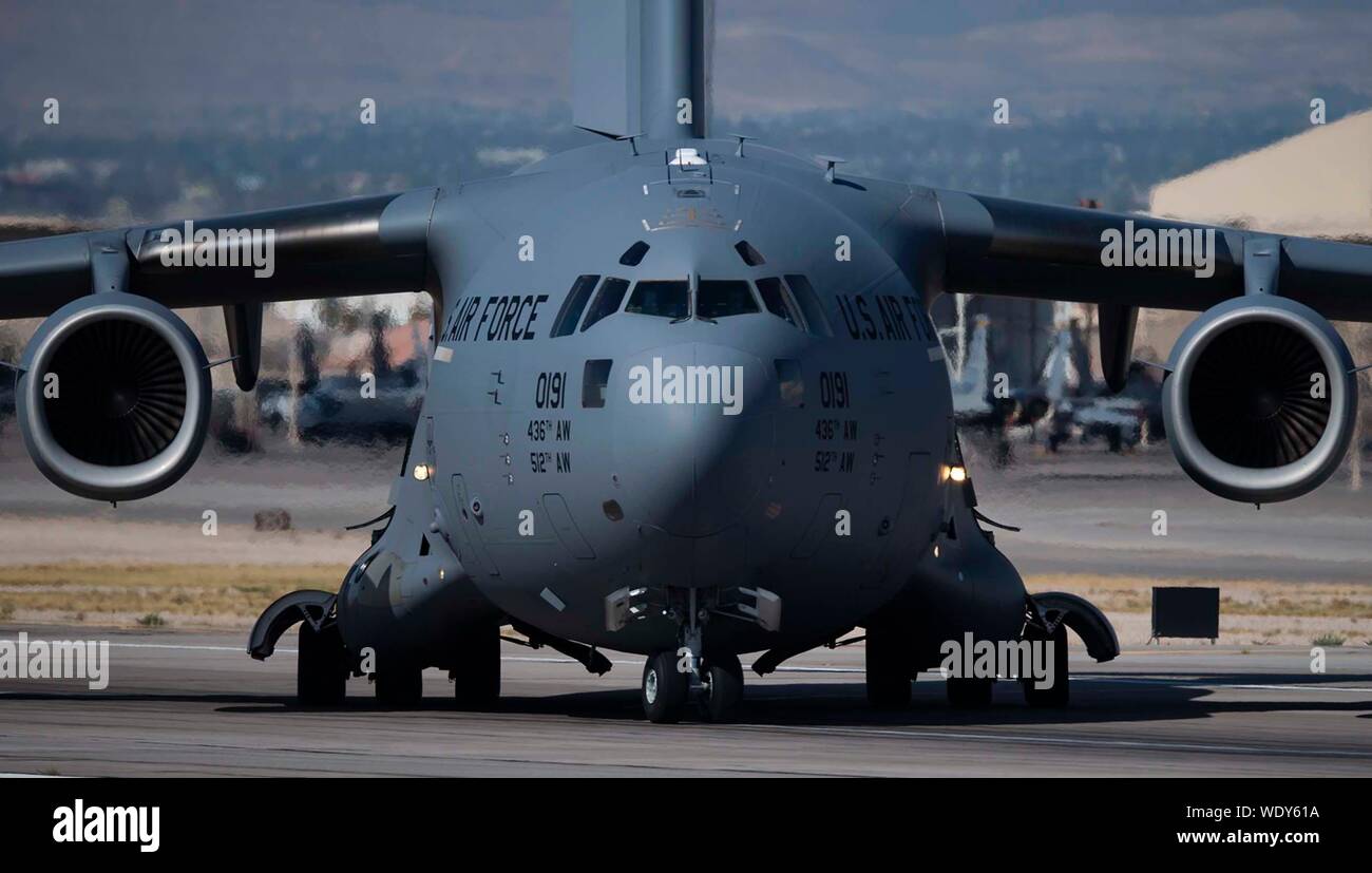 Un C-17A Globemaster III de cargo affecté à la 436e Airlift Wing à Dover Air Force Base (AFB), New York, les taxis sur une piste à Nellis AFB, Nevada, le 8 août 2019. Bien que la mission Nellis met l'accent sur la formation des pilotes de chasse américains, plusieurs cellules de partout dans le monde inonder la piste toute l'année. (U.S. Air Force photo par un membre de la 1re classe Bryan Guthrie) Banque D'Images Un C-17A Globemaster III de cargo affecté à la 436e Airlift Wing à Dover Air Force Base (AFB), New York, les taxis sur une piste à Nellis AFB, Nevada, le 8 août 2019. Bien que la mission Nellis met l'accent sur la formation des pilotes de chasse américains, plusieurs cellules de partout dans le monde inonder la piste toute l'année. (U.S. Air Force photo par un membre de la 1re classe Bryan Guthrie) Banque D'Images