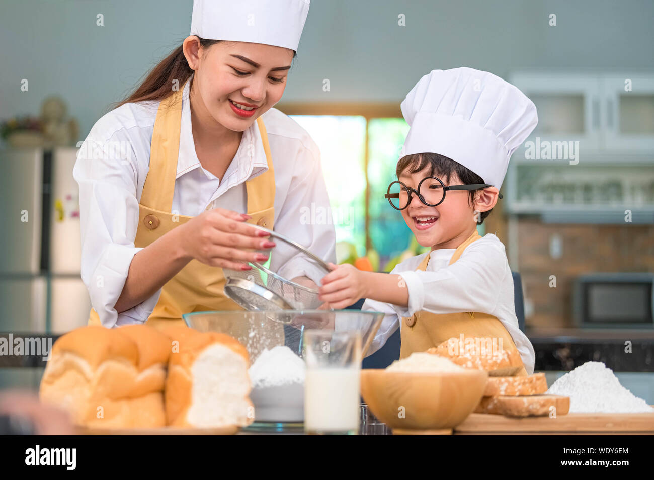 Adorable petit garçon asiatique et belle mère tamisant la farine pâte avec  tamis tamis passoire dans accueil cuisine à table pour se préparer à la  boulangerie et ca Photo Stock - Alamy