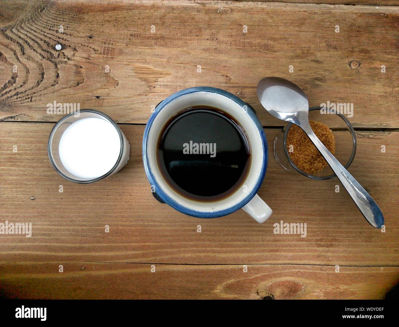 Tourné directement au-dessus de café noir dans le lait et le sucre brun sur la table Banque D'Images