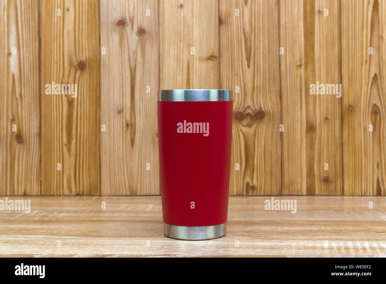 Acier inoxydable couleur rouge gobelet ou tasse de stockage à froid et à chaud sur fond de bois. Banque D'Images