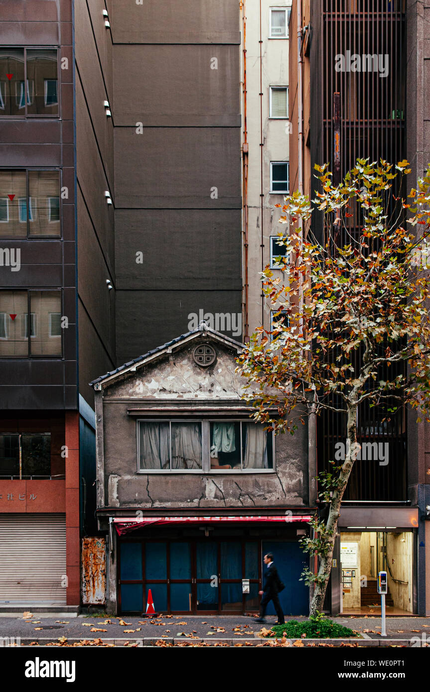 DEC 5, 2018 Tokyo, Japon - vieille petite maison japonaise entre les bâtiments modernes à Kanda quartier d'affaires proche de centre-ville de Tokyo avec l'homme d'affaires local w Banque D'Images