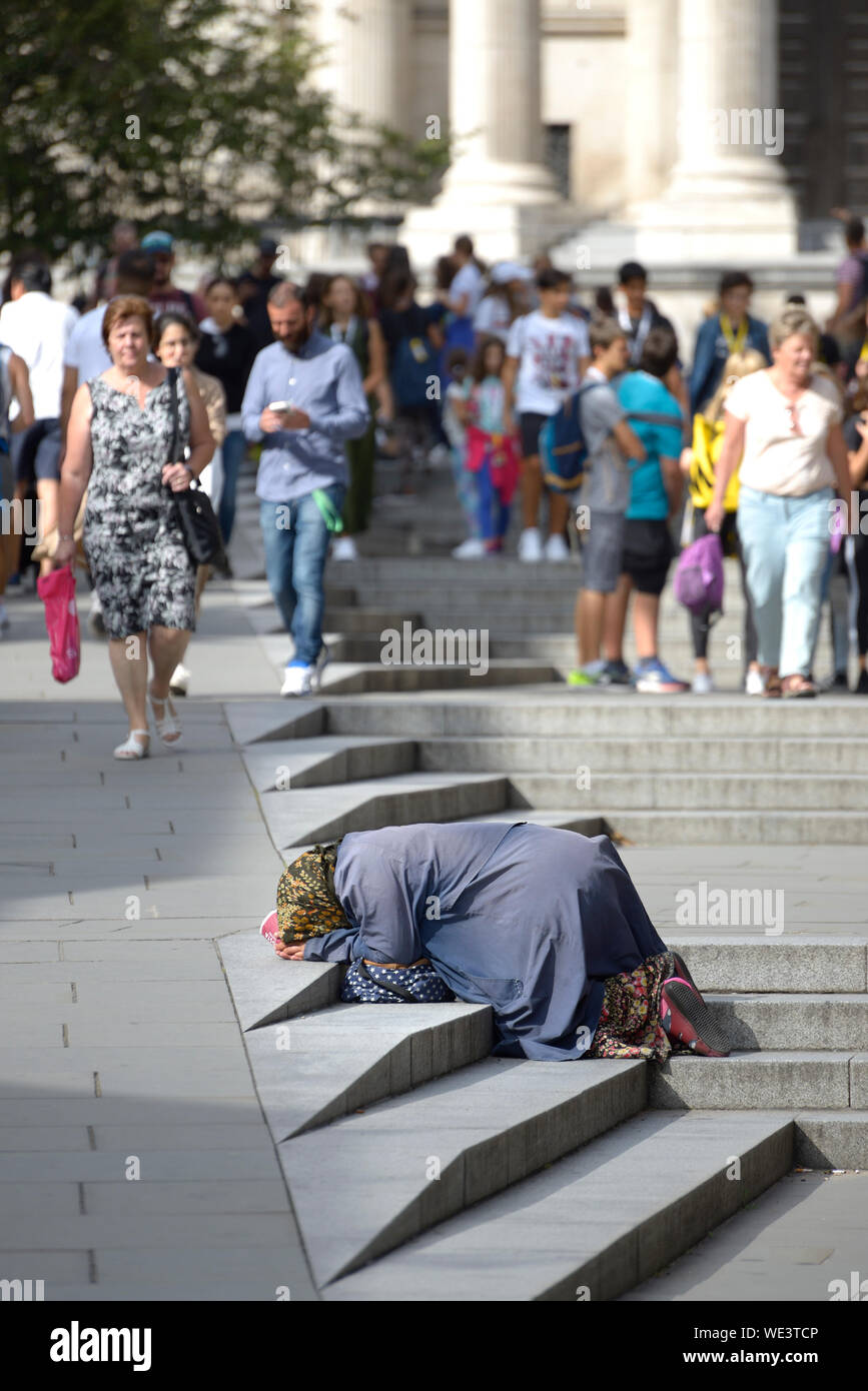 Londres, Angleterre, Royaume-Uni. Femme sans-abri mendier dans les étapes de Peter's Hill, menant à la Cathédrale St Paul Banque D'Images