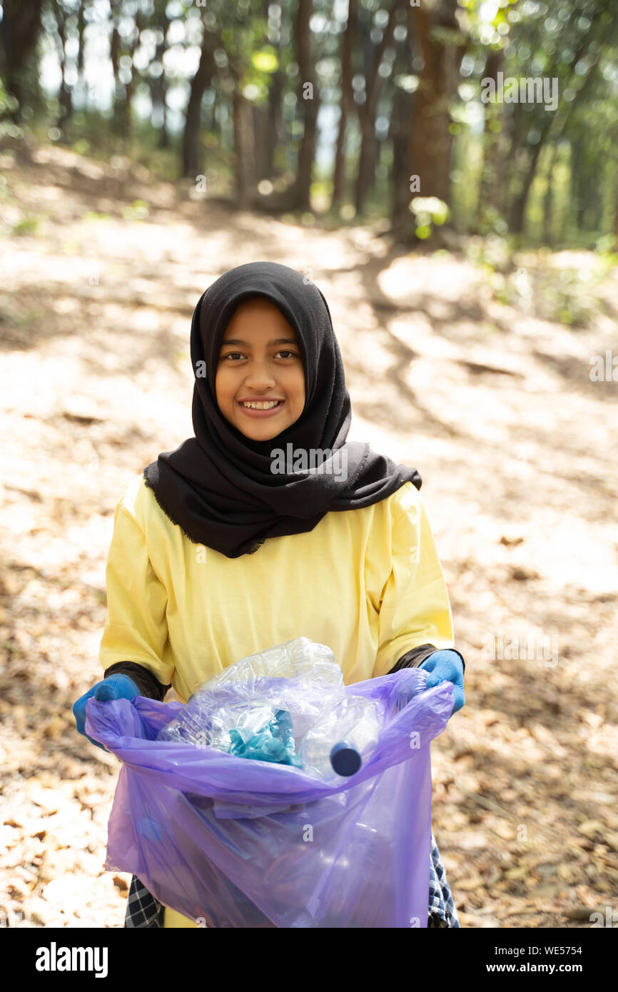 Close up of smiling woman holding hijab bénévoles sac poubelle dans park  Photo Stock - Alamy