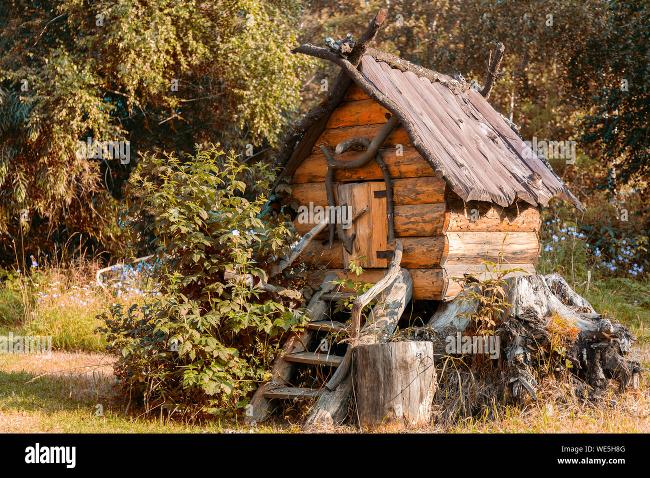 Close-up d'un jouet maison en bois sur les cuisses de poulet dans le jardin sur un fond d'herbe verte sur une chaude journée d'été.La maison de Baba de Yagi Fairy Tales Banque D'Images