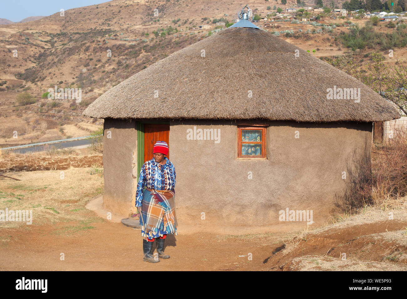 Ramabanta, Lesotho - 20 septembre 2017 : african woman in traditional couverture vêtements dans village proche de l'argile maison avec toit de chaume, le sud de l'Afrique Banque D'Images