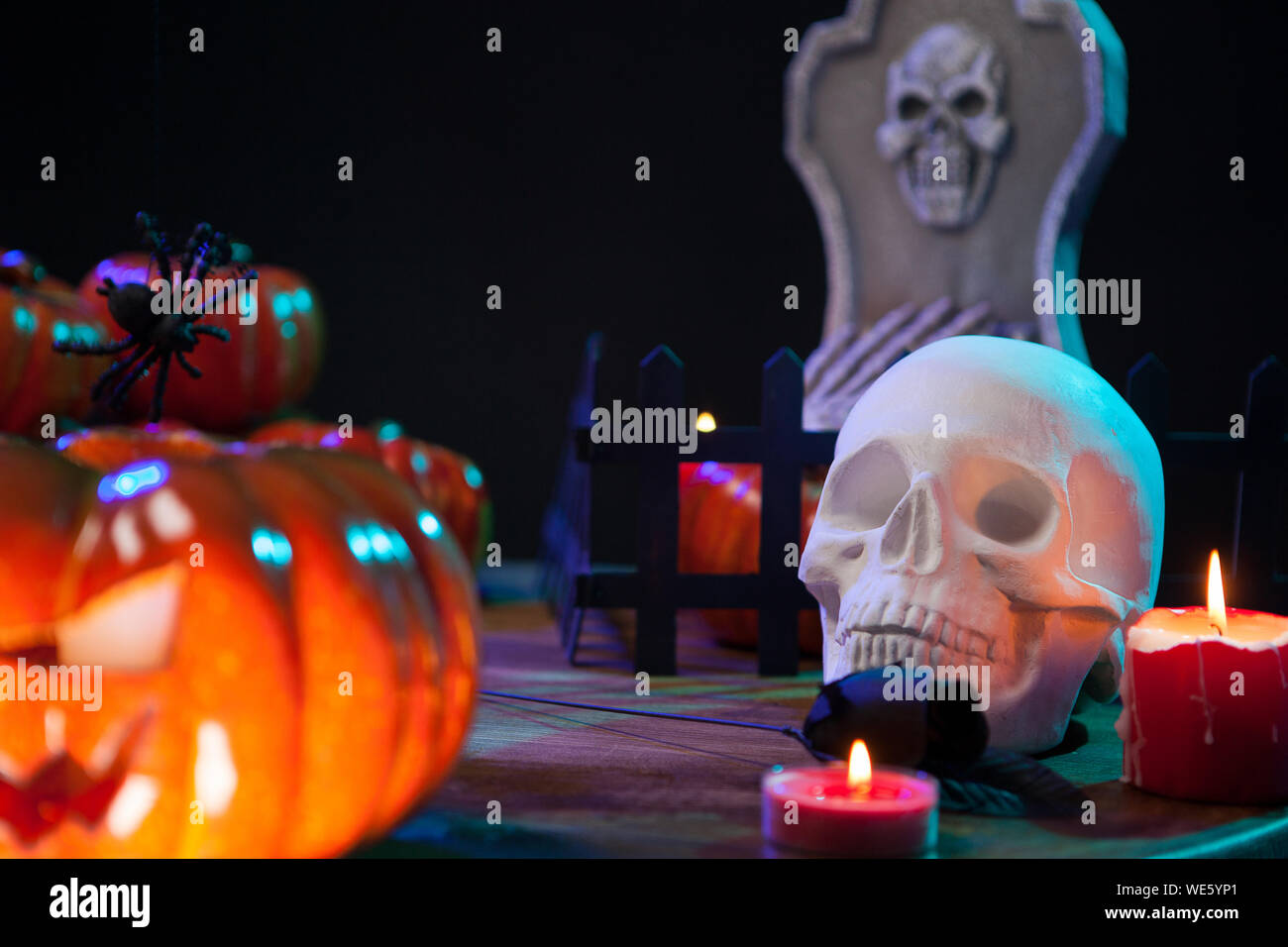 Crâne effrayant sous la lumière des bougies sur une table en bois pour Halloween. Spooky pumpkin. Banque D'Images