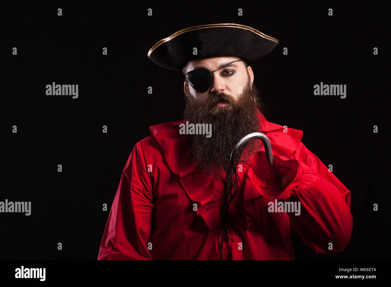 Beau Portrait d'homme barbu portant des vêtements pirate médiévale pour halloween carnaval. L'homme en costume pirate sur fond noir isolé. Banque D'Images