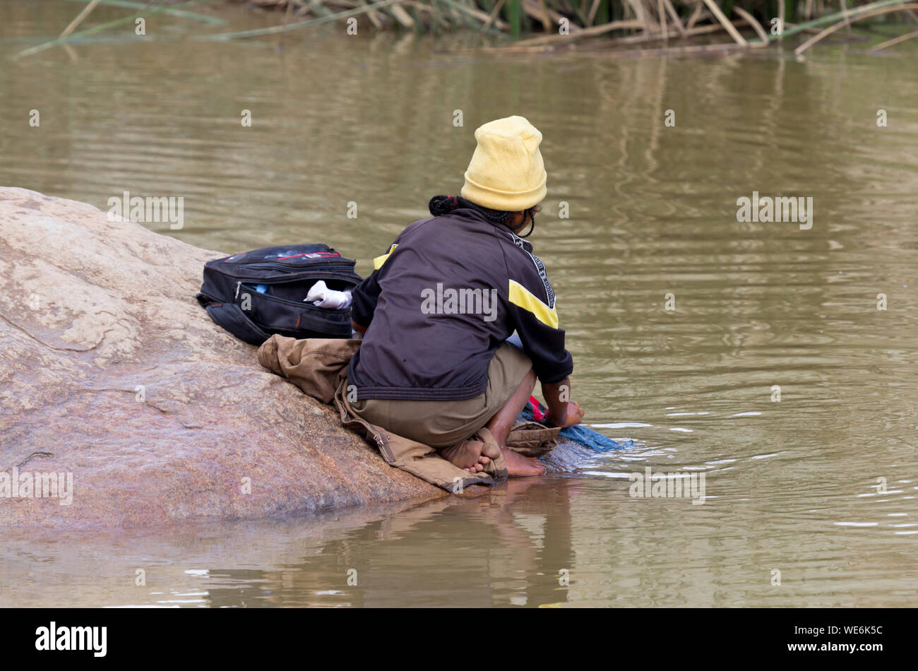 Méconnaissable femme faire la lessive dans une rivière, à Madagascar Banque D'Images