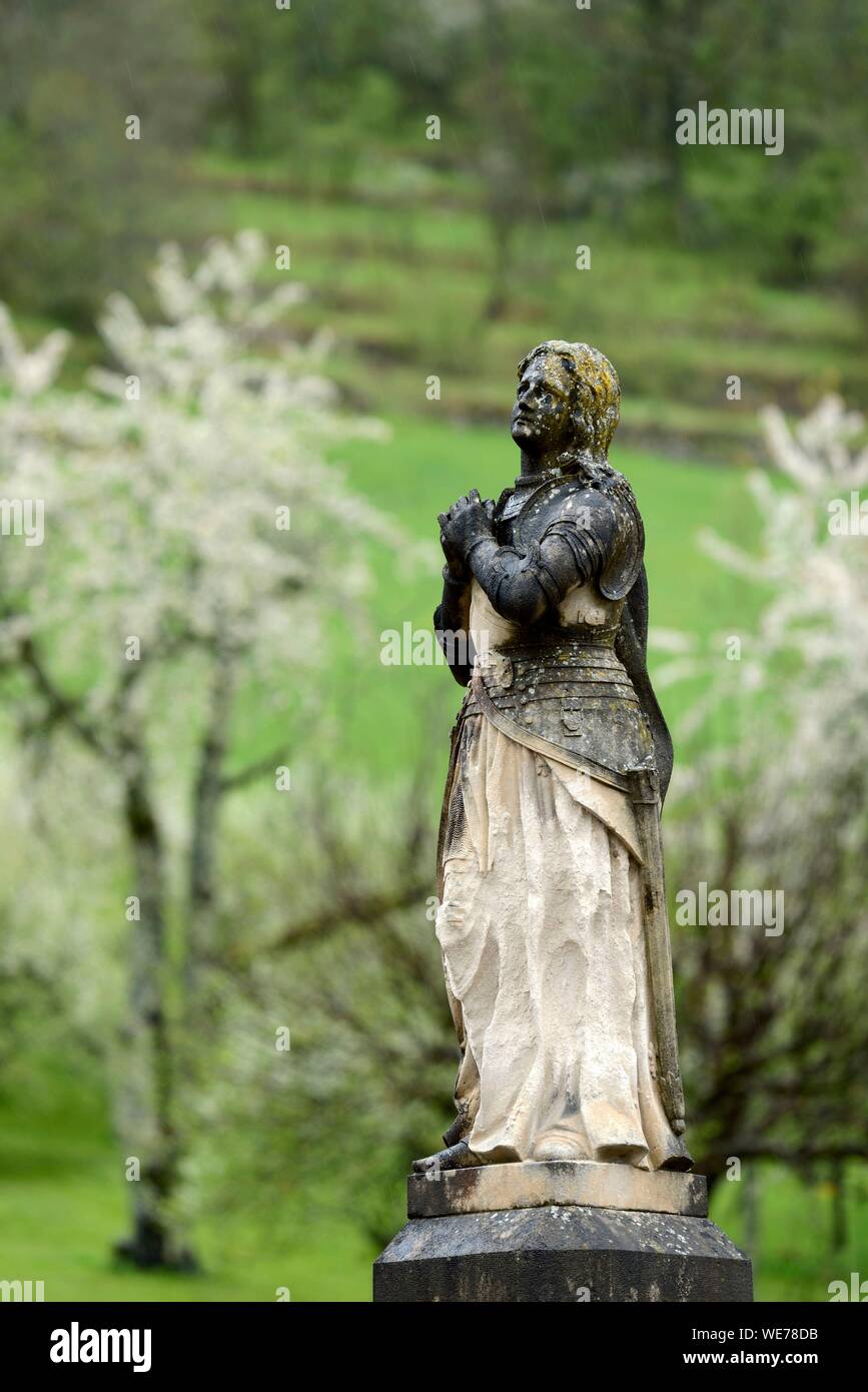 France, Doubs, Mouthier Haute Pierre, parvis de l'église Saint Laurent, en date du 15e siècle, statue de Jeanne d Arc, vergers, fleurs de cerisier en avril Banque D'Images