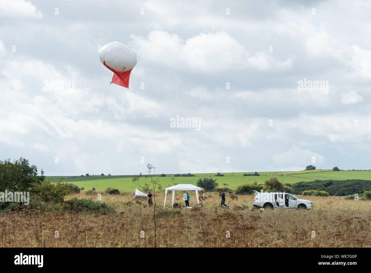 Les scientifiques à l'aide d'un helikite recherche de la biodiversité des insectes à Martin bas National Nature Reserve, une craie downland site dans le Hampshire, au Royaume-Uni Banque D'Images