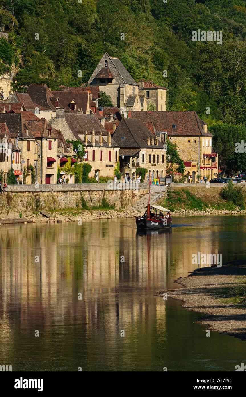 France, Dordogne, La Roque Gageac, Gabare un bateau traditionnel, maisons au bord de la rivière Dordogne et en arrière-plan le château de la Malartrie Banque D'Images