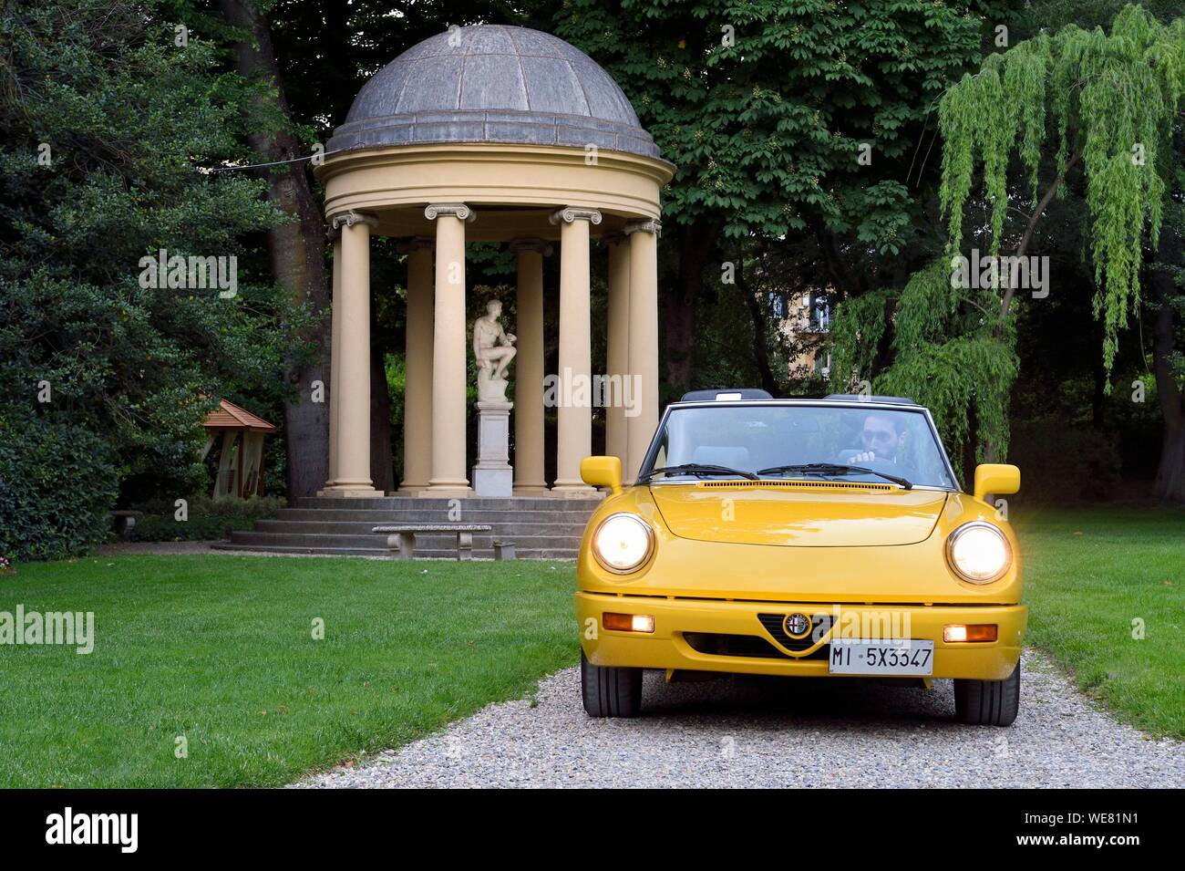 Italie, Toscane, Florence, inscrite au Patrimoine Mondial de l'UNESCO, Alfa Romeo Spider Duetto cabriolet jaune dans les jardins du Palazzo della Gherardesca, palace 5 étoiles Four Seasons Hotel Firenze Banque D'Images