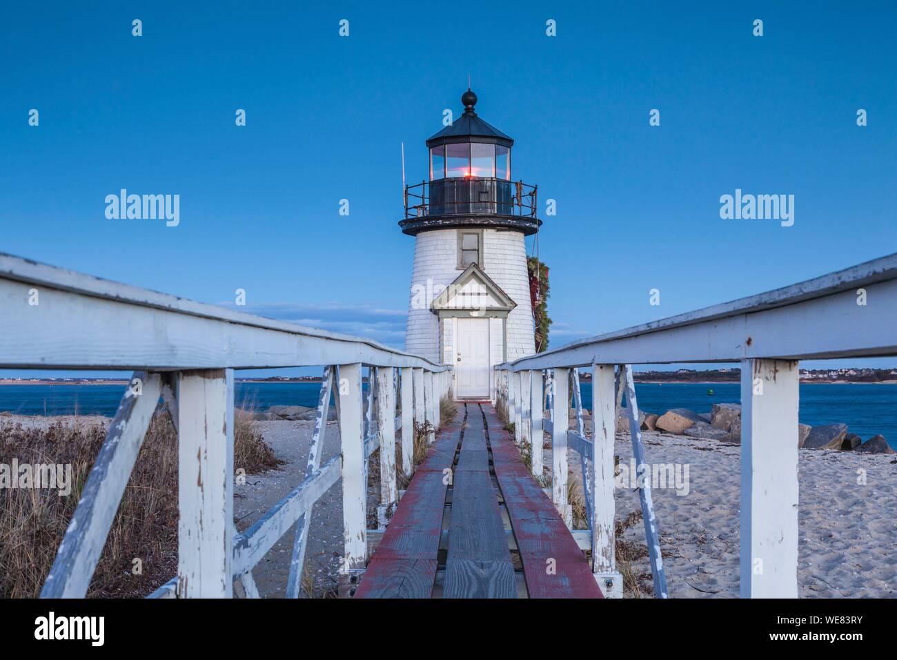 United States, New England, New Jersey, l'île de Nantucket, Nantucket, Brant Point Lighthouse avec une couronne de Noël, dusk Banque D'Images