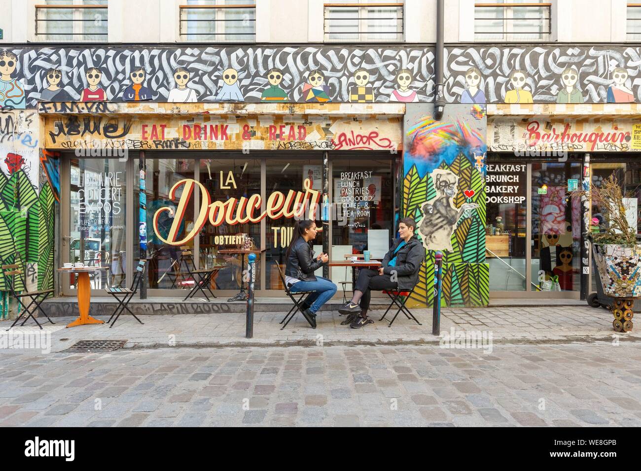France, Paris, art de rue, les graffitis et murales dans Rue Denoyez, la terrasse de l'Barbouquin, café et une librairie Banque D'Images