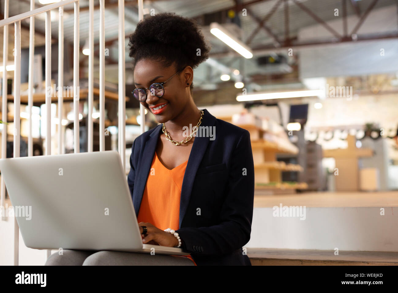 Employé de bureau à l'aide d'Afro-américains tout en travaillant dur pour ordinateur portable Banque D'Images