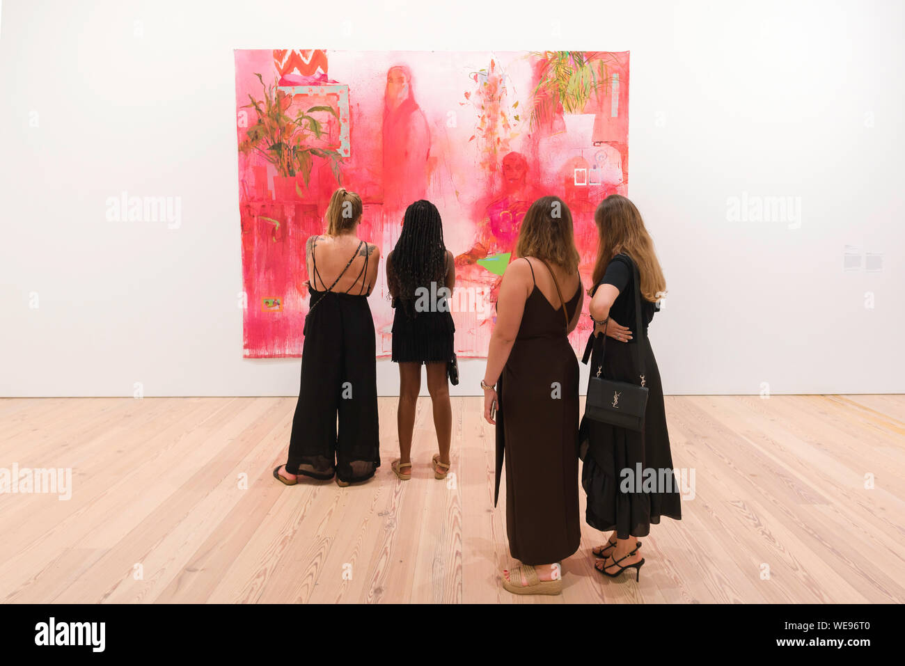 Les femmes de l'art, vue arrière de quatre jeunes femmes à la recherche lors d'une peinture de Jennifer Packer (une leçon dans désir), Whitney Museum of American Art, New York City Banque D'Images