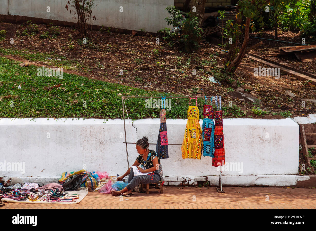 APR 5, 2019 Luang Prabang, Laos - femme du vendeur de souvenirs de la rue sur le trottoir de la rue principale de Luang Prabang. Banque D'Images